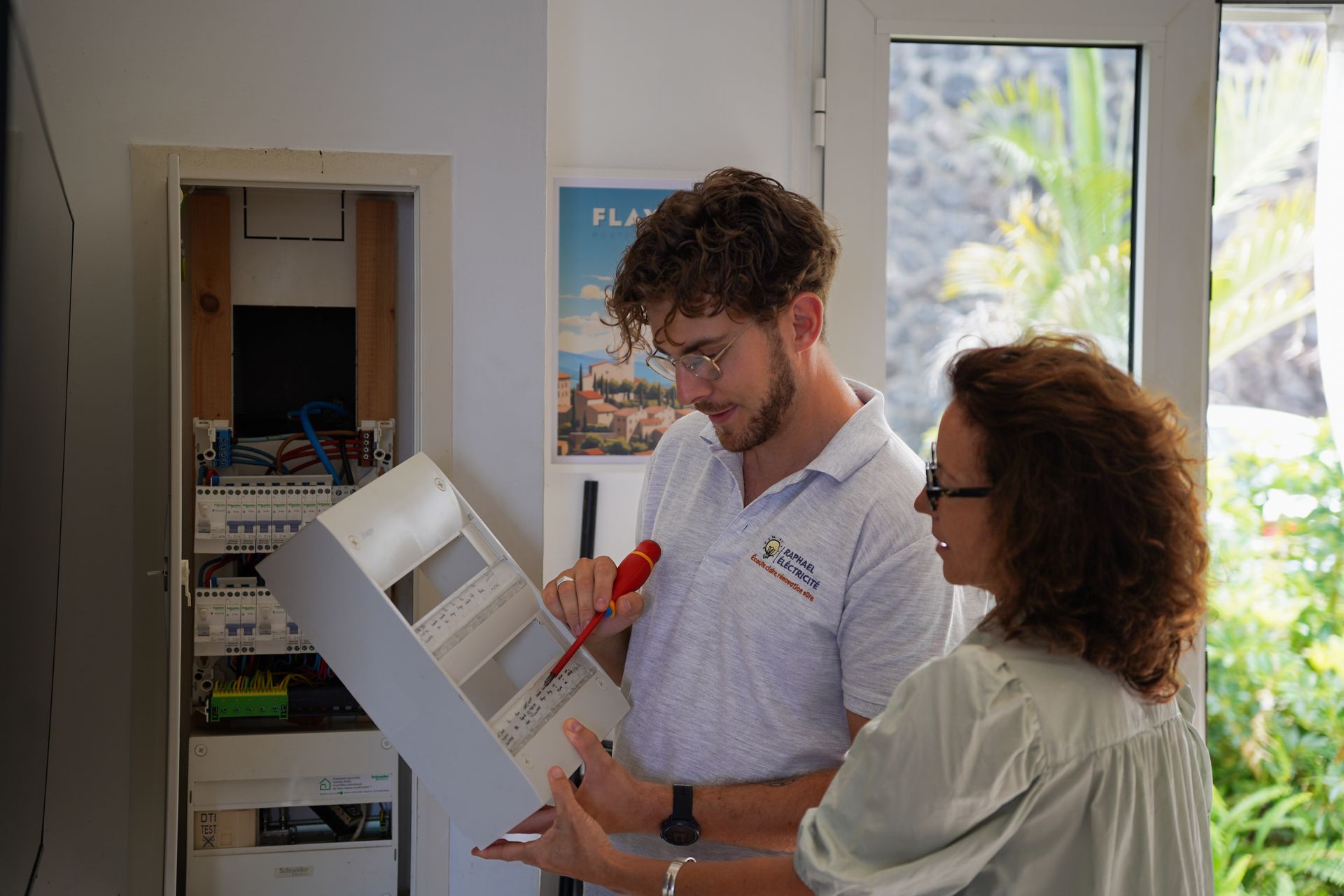 Électricien à Saint-Denis expliquant le fonctionnement d’un circuit électrique à une cliente